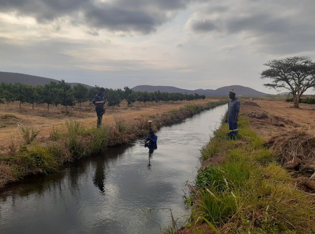 Surveyors measuring along a canal