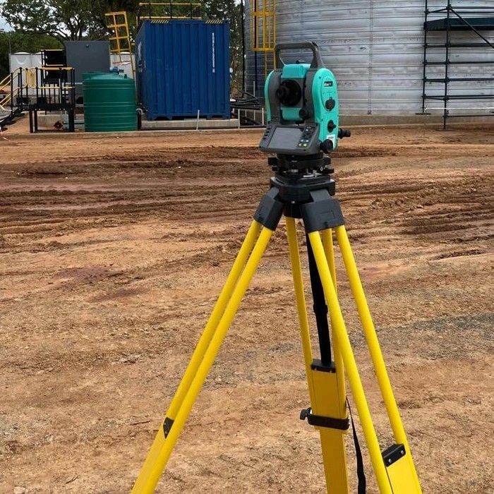 A total station on a yellow tripod on a levelled terrace at Kurmuk
