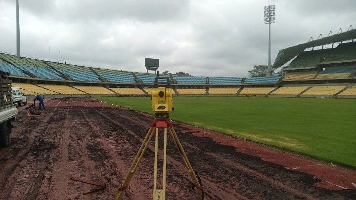 A total station at a stadium with the pitch under construction