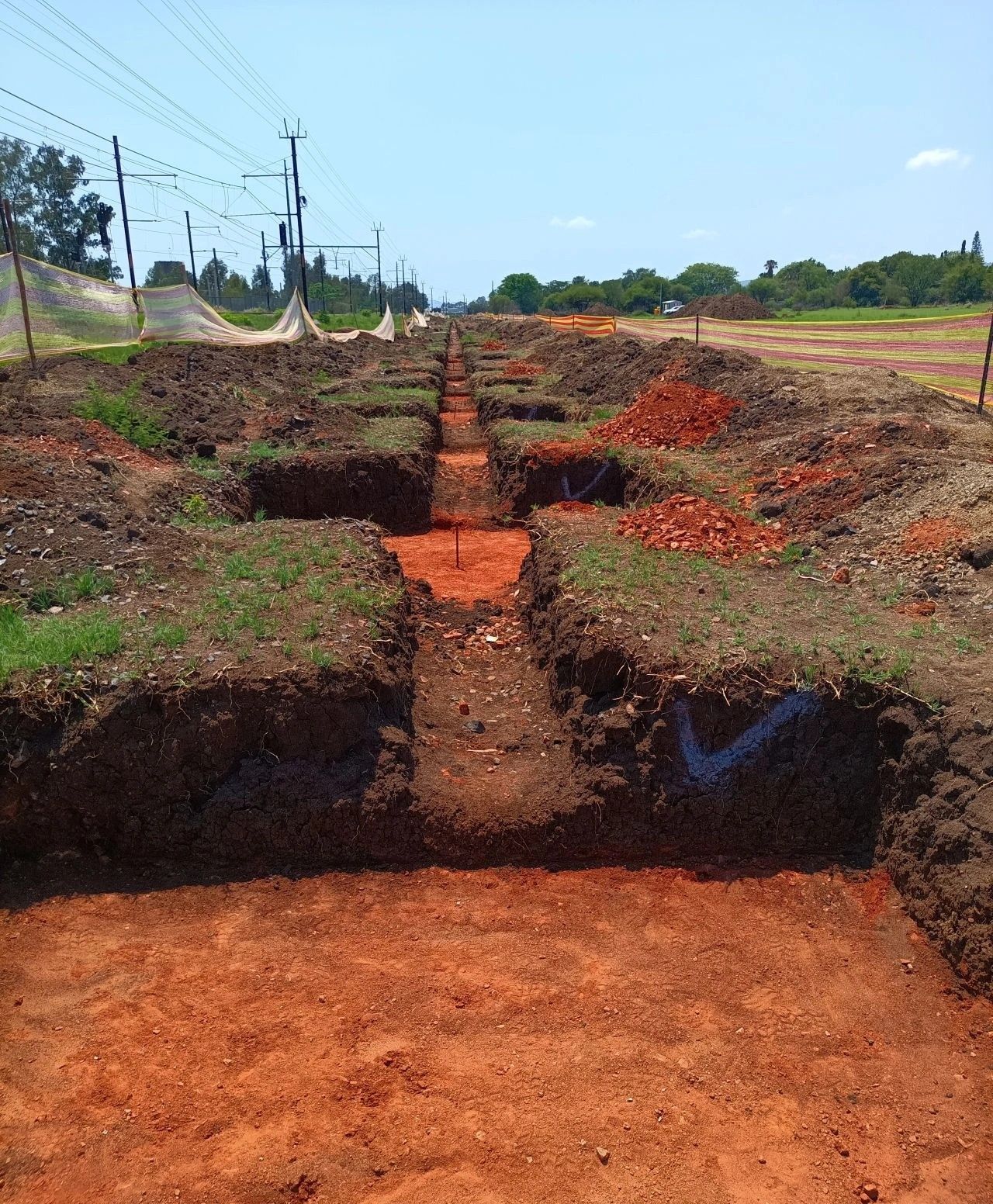 Foundation trenches cut into red soil