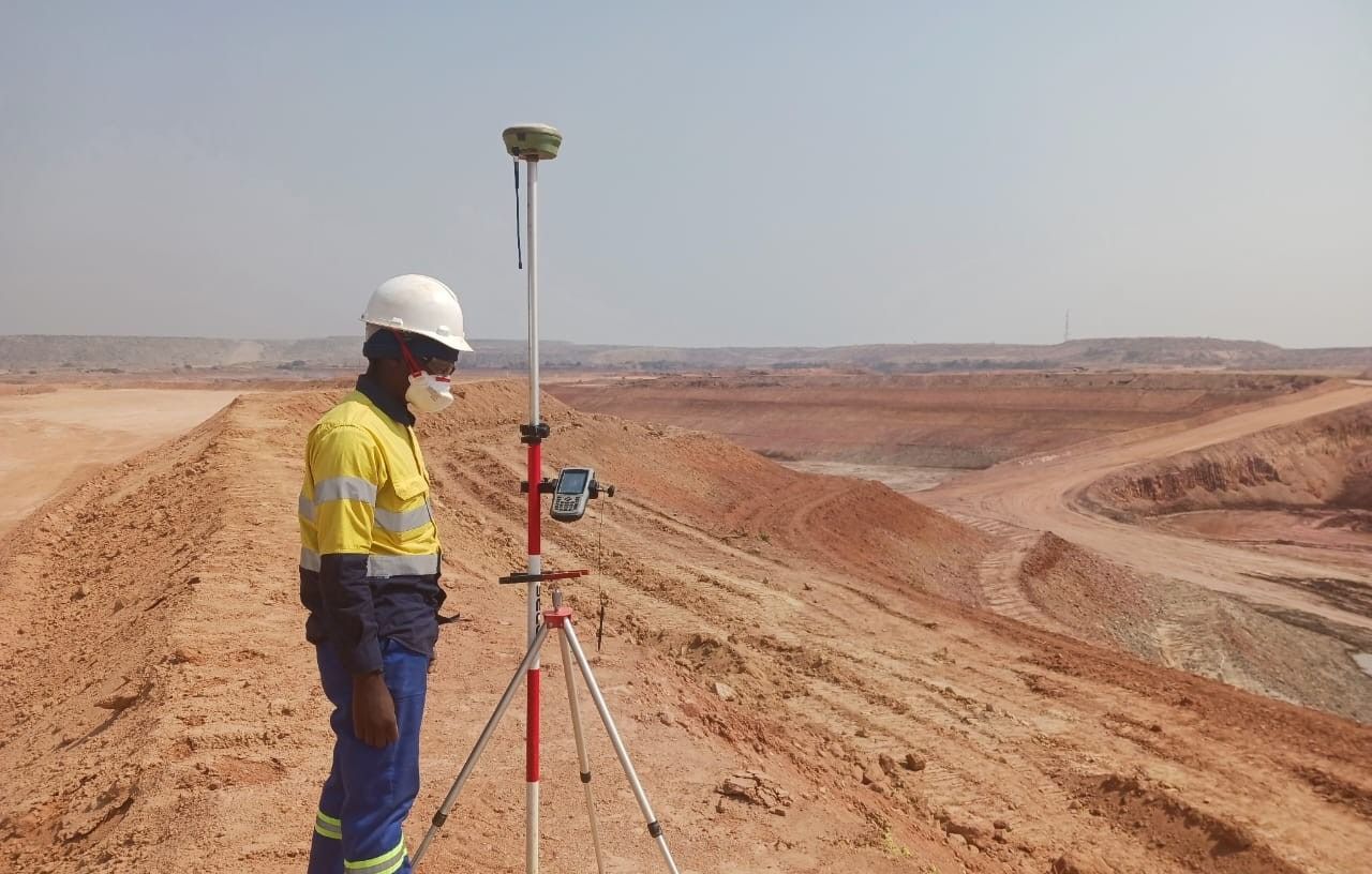A surveyor with a GNSS pole on a haul road at Lumwana Mine