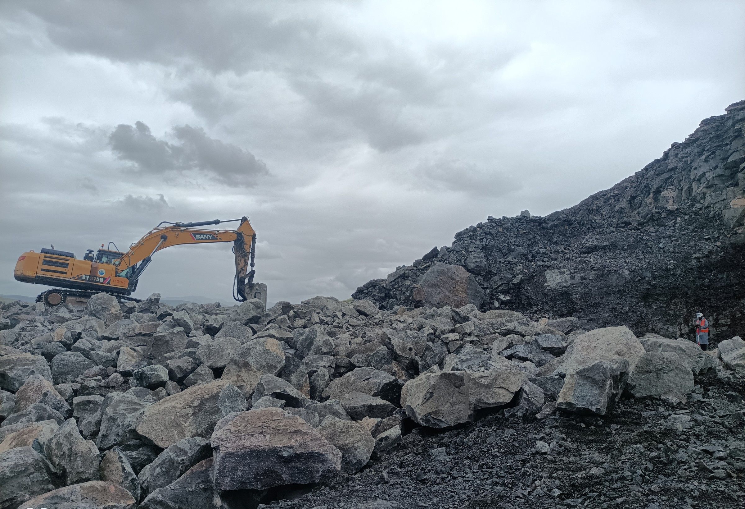An excavator on a blasted rock face