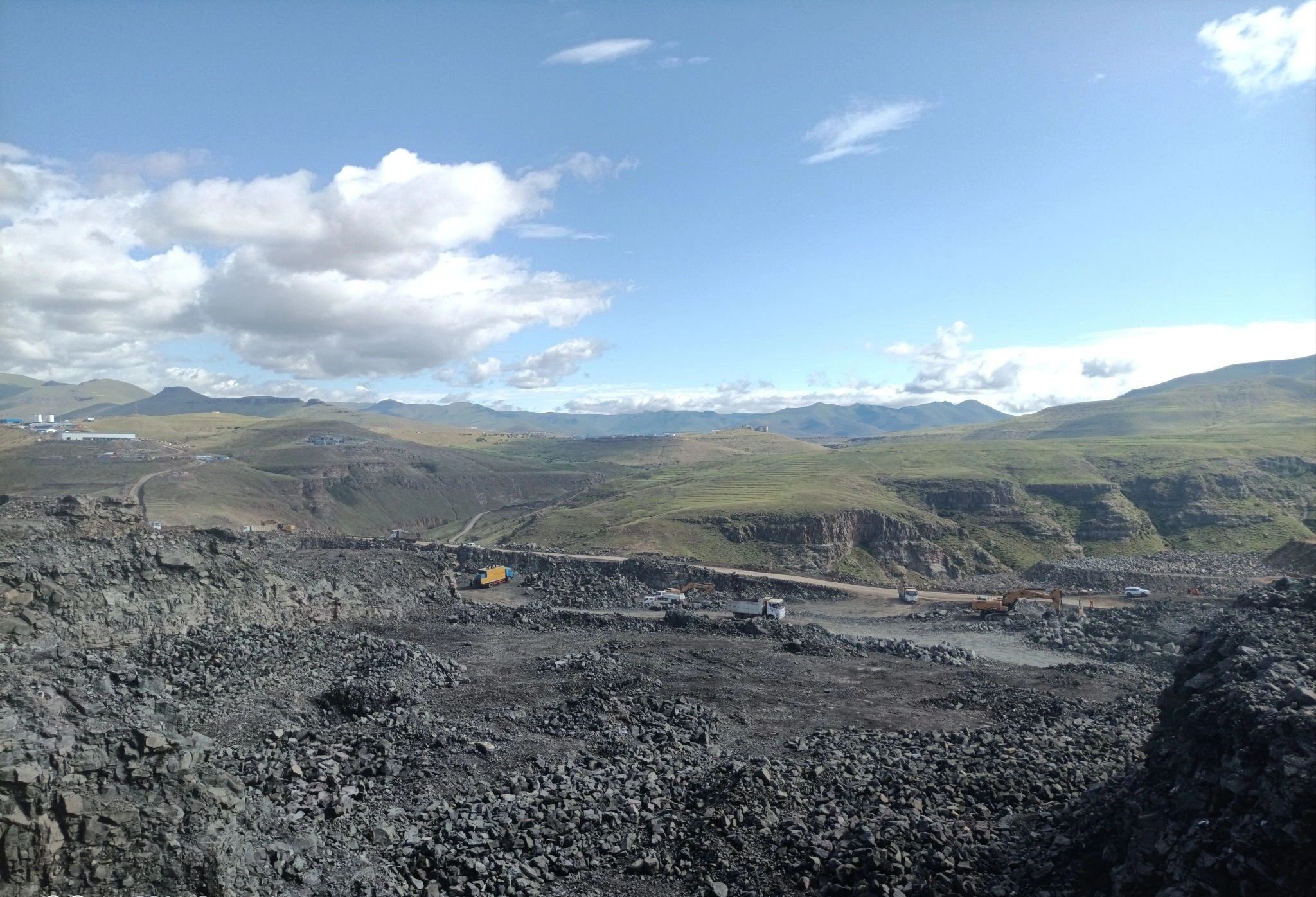 An open pit seen from the rim under a cloudy sky