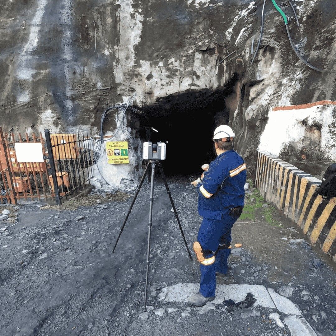 A surveyor with an instrument at the portal of an underground mine