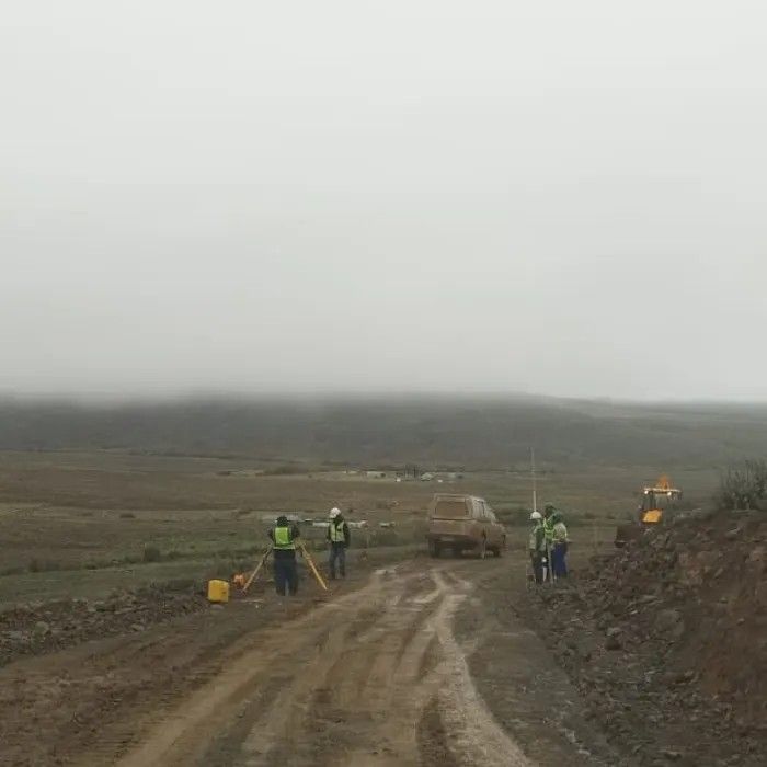 Surveyors walking a track in the mist at the Oya site