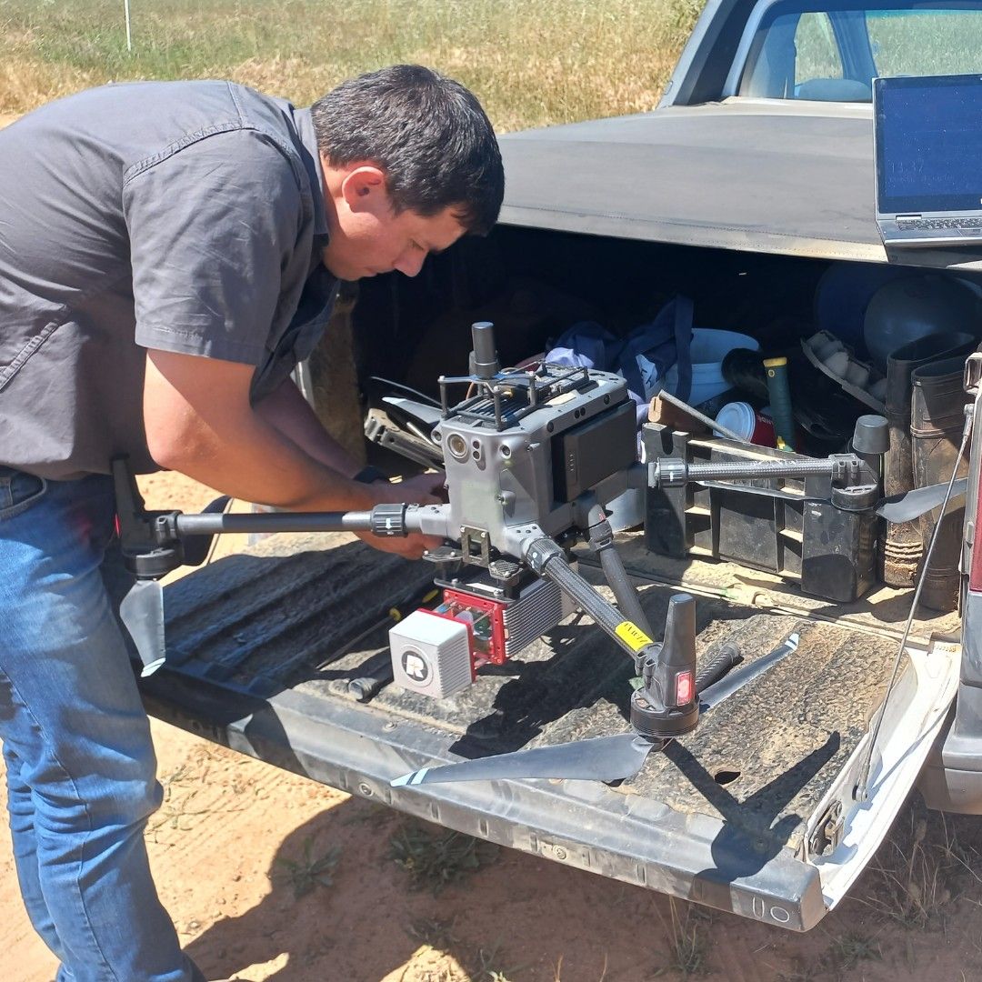 A technician preparing a survey drone on the back of a bakkie